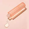 A bottle of Medicube Triple Collagen Toner is shown tilted on a pink background, with a drop of toner falling from the opening. Náhled obrázku produktu