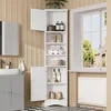 A white corner cabinet with multiple shelves and doors, filled with bathroom items, is shown in a bathroom setting next to a window. Náhled obrázku produktu