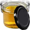 Several glass jars filled with a yellow liquid, one with a black lid placed next to it. Anteprima dell’immagine prodotto