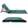 A folded and unfolded beach mat with a tropical print. Produktbild-Vorschau