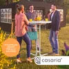 People gathered around a high table outdoors, with a tent in the background. Anteprima dell’immagine prodotto