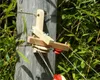 A wooden pulley system attached to a wooden post, with green bamboo foliage in the background. Produktbild-Vorschau