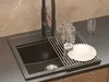 A kitchen sink with a dish drying rack and glasses. Podgląd zdjęcia produktu