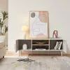 A modern living room scene featuring a beige TV stand with decorative items and artwork. Voir les images du produit