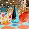 A hanging cocoon swing in a colorful indoor playground. Voir les images du produit
