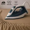 An iron is placed on a brown fabric, likely a bedsheet, with some text and logos in the upper left corner. Produktbild-Vorschau