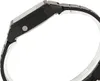 Side view of a black digital watch with a metal band. Voir les images du produit
