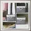 Storage baskets are placed on shelves in a closet, with clothes hanging in the background. Anteprima dell’immagine prodotto