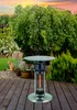 A patio heater table is shown on a wooden deck in a garden setting with a cat in the background. Produktbild-Vorschau