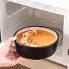 Eine gefüllte Schale wird vor die geöffnete Mikrowelle gehalten.
 Voir les images du produit