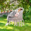 A woman relaxing in a hanging chair in a garden. Náhled obrázku produktu