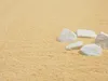 A close-up view of a soft, yellow carpet with several white stones scattered on it. Produktbild-Vorschau