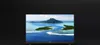 A black television screen displaying a tropical island scene, set against a black background. Produktbild-Vorschau