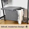 A grey felt storage basket with a lid and a white blanket draped over the side, placed on a black metal shelf unit. Produktbild-Vorschau