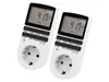 Two white digital timers with digital displays and European-style power outlets are shown against a white background. Produktbild-Vorschau