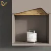 A close-up view of a shelf with a candle on it, and a decorative hook on the wall. Produktbild-Vorschau