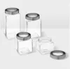 A set of four glass jars with metal lids on a plain background. Anteprima dell’immagine prodotto