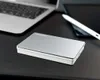 A Toshiba external hard drive is placed on a black desk next to a laptop and a tablet stylus. Produktbild-Vorschau