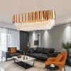 A modern living room with a large rectangular chandelier, black leather sofas, an orange accent chair, and a marble coffee table. Produktbild-Vorschau