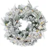 A festive Christmas wreath covered in artificial snow, decorated with pinecones and small white berries, and illuminated by warm white LED lights. Náhled obrázku produktu