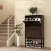 A shoe cabinet with shoes and plants in a hallway next to stairs. Podgląd zdjęcia produktu