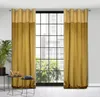 Two golden curtains hang on a window with a grid pattern. A potted plant and two small tables with decorative items are in the foreground. Náhled obrázku produktu
