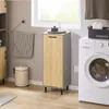 A laundry room scene with a washing machine, a tall cabinet with a wooden door, a trash can, and a towel hanging on a rack. Produktbild-Vorschau