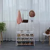 A white metal garment rack with shelves for shoes, holding a pink scarf, a brown handbag, and a brown hat. Anteprima dell’immagine prodotto