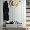 A hallway or entryway with a bench, storage bins, and items hanging on the wall. Produktbild-Vorschau