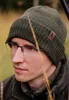 A man wearing a green winter hat and glasses in an outdoor setting. Voir les images du produit