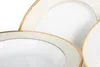 A close-up view of white porcelain plates with a gold and cream decorative rim. Náhled obrázku produktu