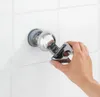 A hand is holding a shower head holder against a tiled wall. Anteprima dell’immagine prodotto