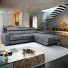 A modern living room with a sectional sofa and a floating staircase.