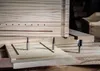 Three router bits are placed on a wooden jig, with more wooden structures in the background. Produktbild-Vorschau