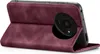 A close-up, angled view of a burgundy flip-style phone case for a Xiaomi Redmi A3, with the phone inside and the camera module visible. Produktbild-Vorschau