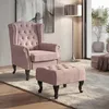 A pink armchair and ottoman are shown in a well-lit living room setting with a floor lamp and artwork. Voir les images du produit