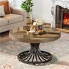 A round wooden coffee table with a metal base is placed in a living room setting, near a sofa and a fireplace. Voir les images du produit