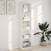 A white bookshelf filled with books and decorative items, placed against a white wall with natural light casting shadows. Voir les images du produit