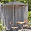 A half umbrella is set up on a balcony next to a small table and chairs. Produktbild-Vorschau