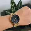 A close-up shot of a person's wrist wearing a gold Casio watch with a black face. Green plants are visible in the background. Produktbild-Vorschau
