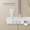 A close-up view of a modern shower system with a glass shelf and controls. Náhled obrázku produktu