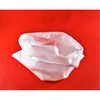 A white mesh bag lies crumpled on a red background. Produktbild-Vorschau