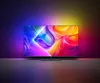 A modern television displaying a vibrant abstract image, with ambient lighting illuminating the wall behind it. Voir les images du produit