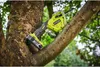 A Ryobi electric chainsaw is attached to a tree branch. Podgląd zdjęcia produktu