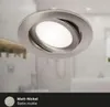 A close-up of a silver LED recessed light fixture with a modern design, set against a blurred bathroom background. Produktbild-Vorschau