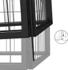 A close-up view of a black metal dog crate, showing the door mechanism and how it attaches to the main body of the crate. A small circular inset diagram illustrates the insertion of a pin into the ground. Náhled obrázku produktu