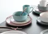 A collection of ceramic tableware, including bowls, plates, and mugs, arranged on a dark surface. Náhľad obrázku produktu