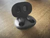 Black wireless earbuds in their charging case, placed on a wooden surface. Anteprima dell’immagine prodotto