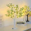 Two decorative LED trees with green and white leaves are displayed on a white surface, with books and a sign in the background. Produktbild-Vorschau