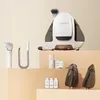A white and bronze Uwant fabric stain cleaner with various accessories displayed on a multi-tiered beige surface. Podgląd zdjęcia produktu